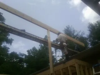 Carpenter setting a ridge beam over a new addition frame — Ice Dam Removal by Roofing Brothers in Hazelton