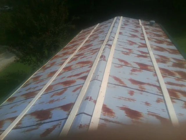 Rusted metal roof panels with new wood purlins before replacement — Storm Damage Roof Repair in Hazelton by Roofing Brothers