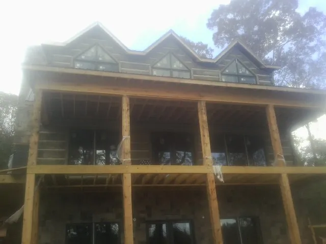 Dormers and porch framing on a large log home under construction — Roof Coating work by our crew in Hazelton
