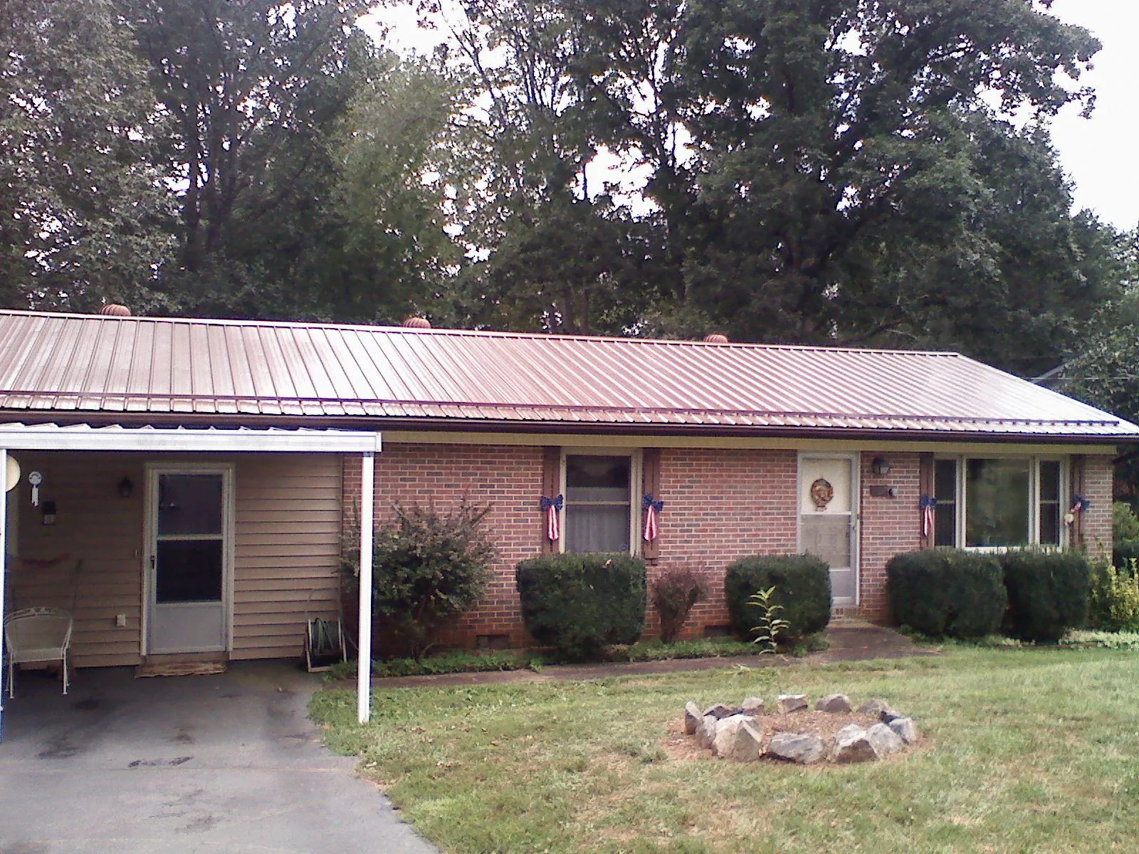 Bronze metal roof and carport on a brick ranch home — Roof Repair work by our crew in Hazelton